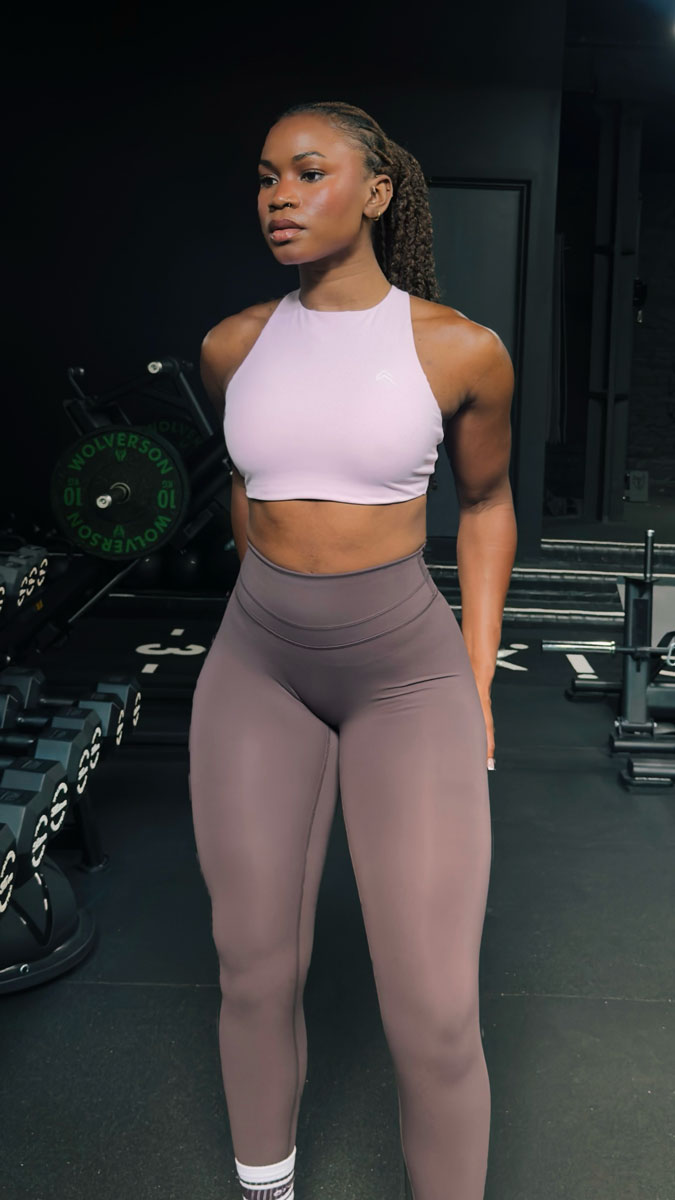 The coach is posing while wearing purple clothing.